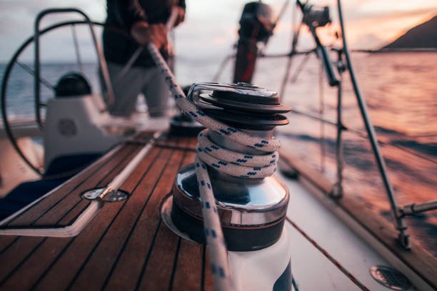The deck of a sailboat, often bathed in the crisp embrace of sea air and the shimmering dance of sunlight on the water, is a place of purposeful activity. Amidst the intricate network of lines and the sturdy gleam of stainless steel, a seemingly simple act unfolds: a person operating a winch. This image, though perhaps fleeting, captures a fundamental element of sailing – the direct and skillful management of the wind's power. The scene is more than just a snapshot; it's a testament to the harmonious relationship between human intention, mechanical advantage, and the untamed energy of the sea. The rhythmic whir often associated with this activity can signal an imminent shift in the vessel's behavior, a subtle adjustment that translates into a change of speed or direction. This visual moment encapsulates a dynamic interplay where the sailor's interaction with the winch is poised to influence the boat's journey. The act of operating this piece of equipment visually represents the sailor's immediate connection to the forces of nature, as the wind's pressure on the sails translates into tangible tension on the lines controlled by the winch. Furthermore, the specific conditions of the environment – whether a gentle breeze or a more forceful gust – likely dictate the intensity and frequency of such winch operations, hinting at the constant awareness and expertise demanded of those who navigate by sail.