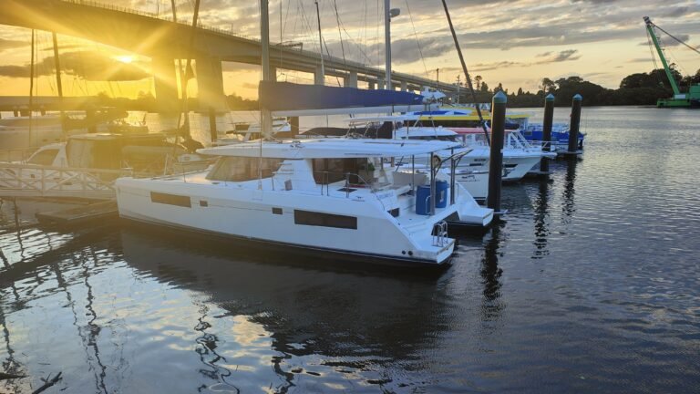 a leopard 45 catamaran tied under a bridge in Brisbane at sunrise with the orange glow highly visible at the left edge
